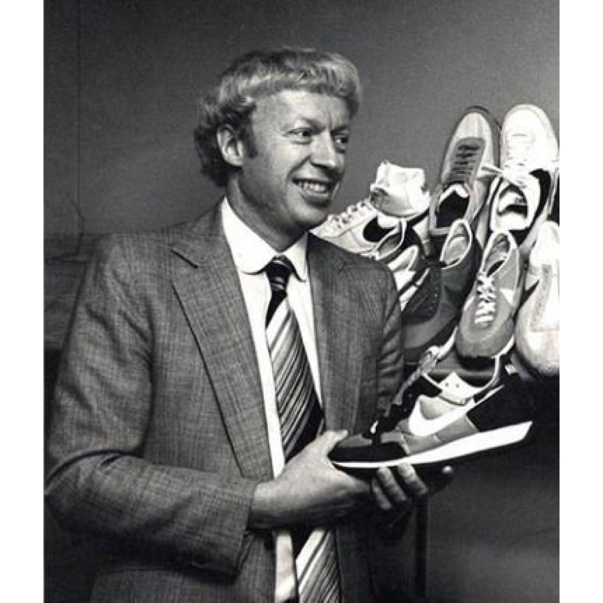 Phil Knight, fundador de la marca Nike sujetando un tenis deportivo